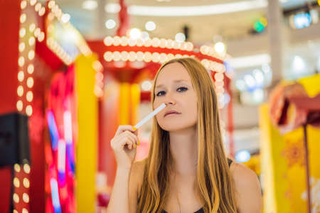 A woman with paper strips in her hands listens to the fragrance in the mallの写真素材