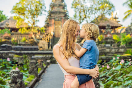 Mom and son travelers in the background of Pura Taman Kemuda Saraswati Temple in Ubud, Bali island, Indonesia Traveling with children conceptの写真素材