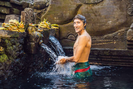 Man in holy spring water temple in bali. The temple compound consists of a petirtaan or bathing structure, famous for its holy spring waterの写真素材