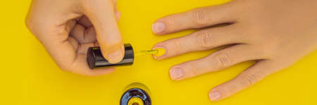Woman Hands Care. Top View Of Beautiful Smooth Woman's Hands With Professional Nail Care Tools For Manicure On yellow Background. Closeup Of Healthy Female Nails With yellow Nail Polish. High Resolution. BANNER, LONG FORMATの写真素材