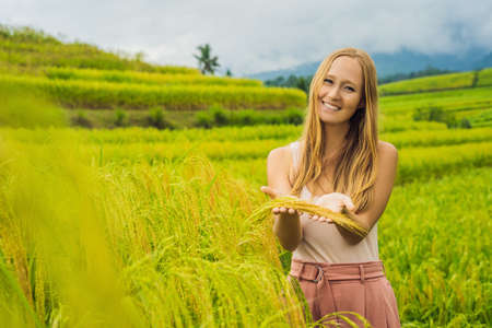 Young woman traveler on Beautiful Jatiluwih Rice Terraces against the background of famous volcanoes...