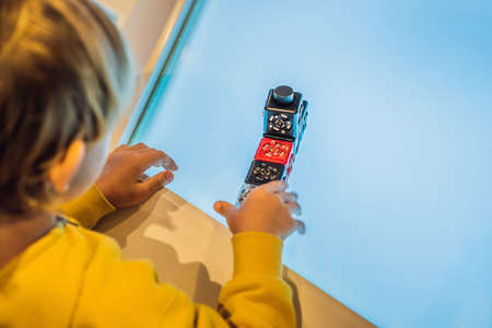 The boy plays with the electronic designer on the light table