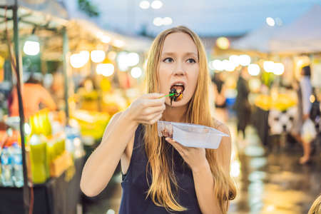 Young woman tourist on Walking street Asian food marketの写真素材