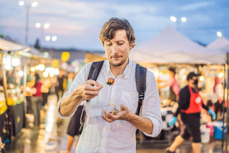 Young man tourist on Walking street Asian food marketの写真素材