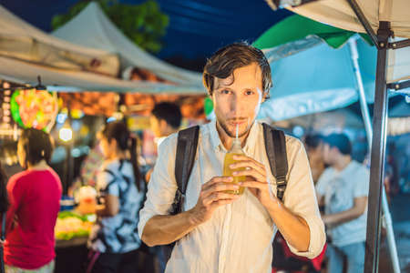 Man drinking sugar cane juice on the Asian marketの写真素材