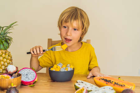 Boy eats fruit. Healthy food for children. Child eating healthy snack. Vegetarian nutrition for kids. Vitamins for childrenの写真素材