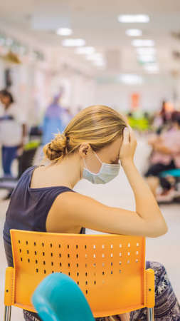 Young woman sitting in hospital waiting for a doctors appointment. Patients In Doctors Waiting Room...