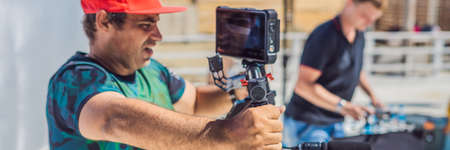 the production team on a commercial video shoot. Steadicam operator uses the 3-axis camera...