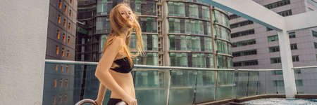 Young woman in the pool among the skyscrapers and the big city. Relax in the big city. Rest from stress BANNER, LONG FORMATの写真素材
