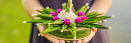 Young woman celebrates Loy Krathong, Runs on the water. Loy Krathong festival, People buy flowers and candle to light and float on water to celebrate the Loy Krathong festival in Thailand BANNER, LONG FORMATの写真素材