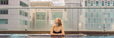 Young woman in the pool among the skyscrapers and the big city. Relax in the big city. Rest from stress BANNER, LONG FORMATの写真素材