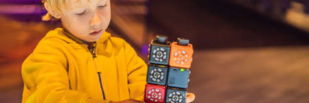 The boy plays with the electronic designer on the light table BANNER, LONG FORMAT
