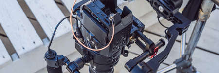 Steadicam operator and his assistant prepare camera and 3-axis stabilizer-gimbal for a commercial shoot BANNER, LONG FORMATの写真素材