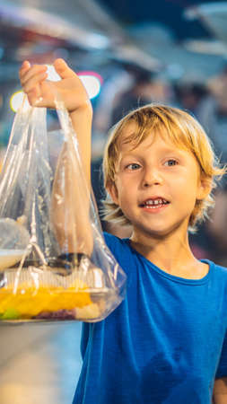 Young boy tourist on Walking street Asian food market VERTICAL FORMAT for mobile story or stories size. Mobile wallpaperの写真素材