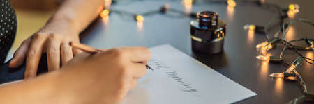 Calligrapher hands writes phrase on white paper. Phrase - Good morning. Inscribing ornamental decorated letters. Calligraphy, graphic design, lettering, handwriting, creation concept BANNER, LONG FORMATの写真素材