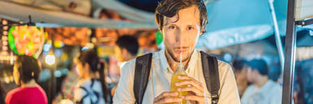 Man drinking sugar cane juice on the Asian market BANNER, LONG FORMAT