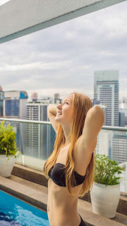 Young woman in the pool among the skyscrapers and the big city. Relax in the big city. Rest from stress VERTICAL FORMAT for mobile story or stories size. Mobile wallpaperの写真素材