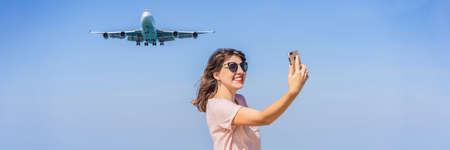Woman makes a selfie on the beach watching the landing planes. Traveling on an airplane concept. Text space. Island Phuket in Thailand. Impressive paradise. Hot beach Mai Khao. Amazing landscape BANNER, LONG FORMATの写真素材