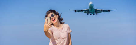Woman makes a selfie on the beach watching the landing planes. Traveling on an airplane concept. Text space. Island Phuket in Thailand. Impressive paradise. Hot beach Mai Khao. Amazing landscape BANNER, LONG FORMATの写真素材