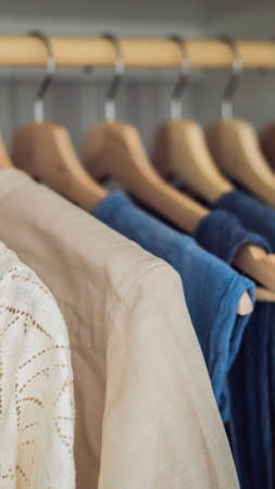 Clothes on hangers in the cabinet gradient from white to dark blue VERTICAL FORMAT for mobile story or stories size. Mobile wallpaperの写真素材