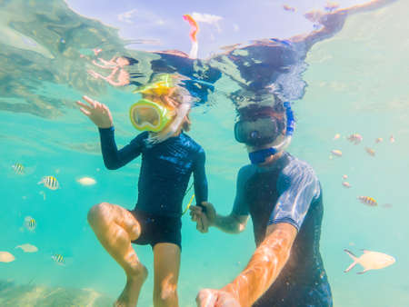 Underwater portrait of father and son snorkeling togetherの写真素材