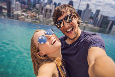 young happy and attractive playful couple taking selfie picture together at luxury urban hotel...