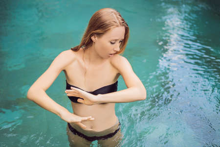 Frustrated young woman having a bad skin in the pool. Due to the fact that chemicals in the poolの写真素材