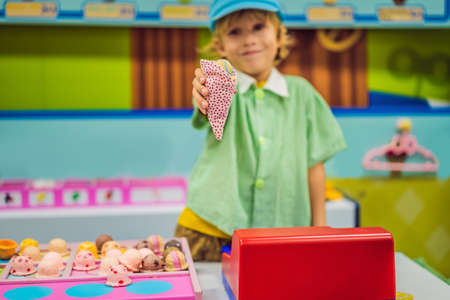A boy plays in a toy kitchen, makes a toy ice creamの写真素材