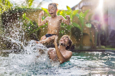 Dad and son have fun in the poolの写真素材