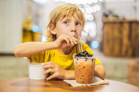 Boy eating ice cream in a cafeの写真素材
