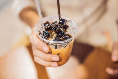 Man drinking cold bubble tea in cafeの写真素材