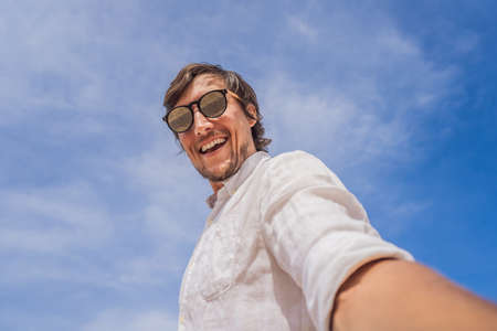 A man takes a selfie against the skyの写真素材