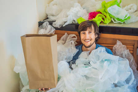 Man holding paper bag amid a pile of plastic bags. Zero waste concept. The concept of World...