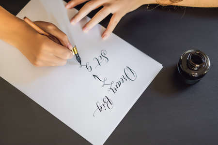 dream big set goals take action. Calligrapher Young Woman writes phrase on white paper. Inscribing ornamental decorated letters. Calligraphy, graphic design, lettering, handwriting, creation conceptの写真素材