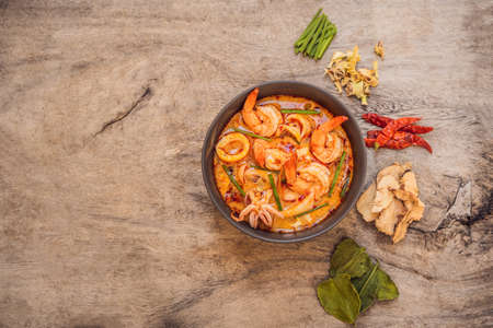Prawn and lemon grass soup with mushrooms,Tom Yam Kung ,thai food in wooden background, top viewの写真素材