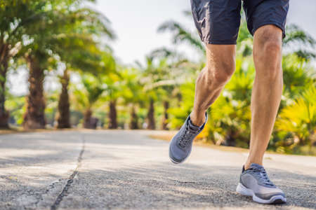 Runner athlete running at tropical park. man fitness sunrise jogging workout wellness concept