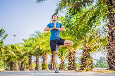 Man doing yoga in a tropical parkの写真素材