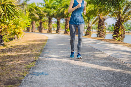 Runner athlete running at tropical park. woman fitness sunrise jogging workout wellness concept
