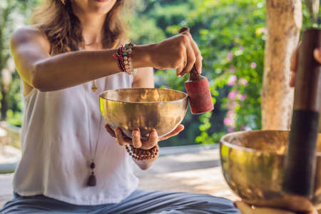 Nepal Buddha copper singing bowl at spa salon. Young beautiful woman doing massage therapy singing...