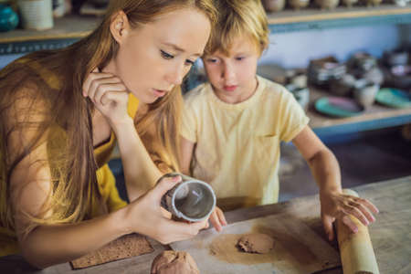 mother and son doing ceramic pot in pottery workshop