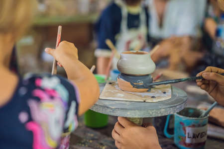 mother and son doing ceramic pot in pottery workshopの写真素材