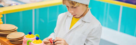 Boy plays the game as if he were a cook in a childrens kitchen BANNER, LONG FORMAT