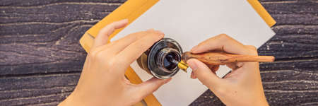 Womens hands in a wooden background holding a signboard, drawing block, paper, mockup BANNER, LONG FORMATの写真素材