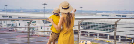 BANNER, LONG FORMAT Family at airport before flight. Mother and son waiting to board at departure...