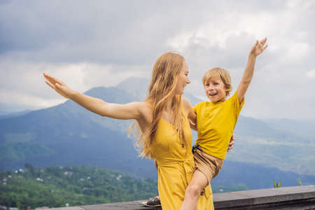 Mom and son tourists on background looking at Batur volcano. Indonesia. Traveling with kids conceptの写真素材