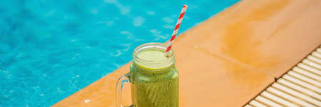 Green smoothies of spinach and banana on the background of the pool. Healthy food, healthy smoothies BANNER, LONG FORMATの写真素材