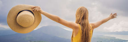 Woman traveler looking at Batur volcano. Indonesia BANNER, LONG FORMATの写真素材