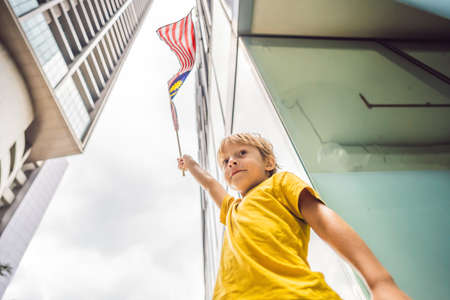 Young boy tourist with the flag of Malaysia near the skyscrapers. Traveling with kids conceptの写真素材