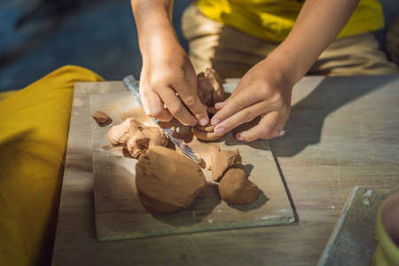 mother and son doing ceramic pot in pottery workshop. What to do with children. Child friendly placeの写真素材