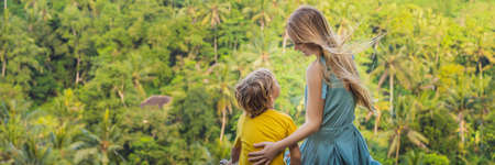 Mom and son tourists on a stone over the jungle.の写真素材